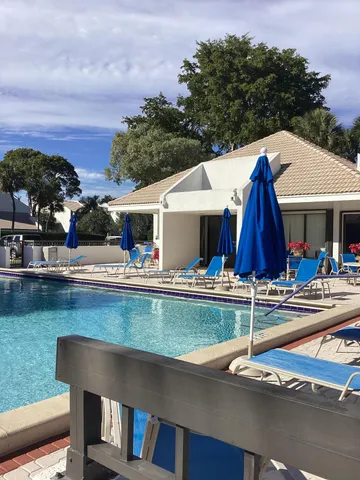 a view of a house with swimming pool and sitting area