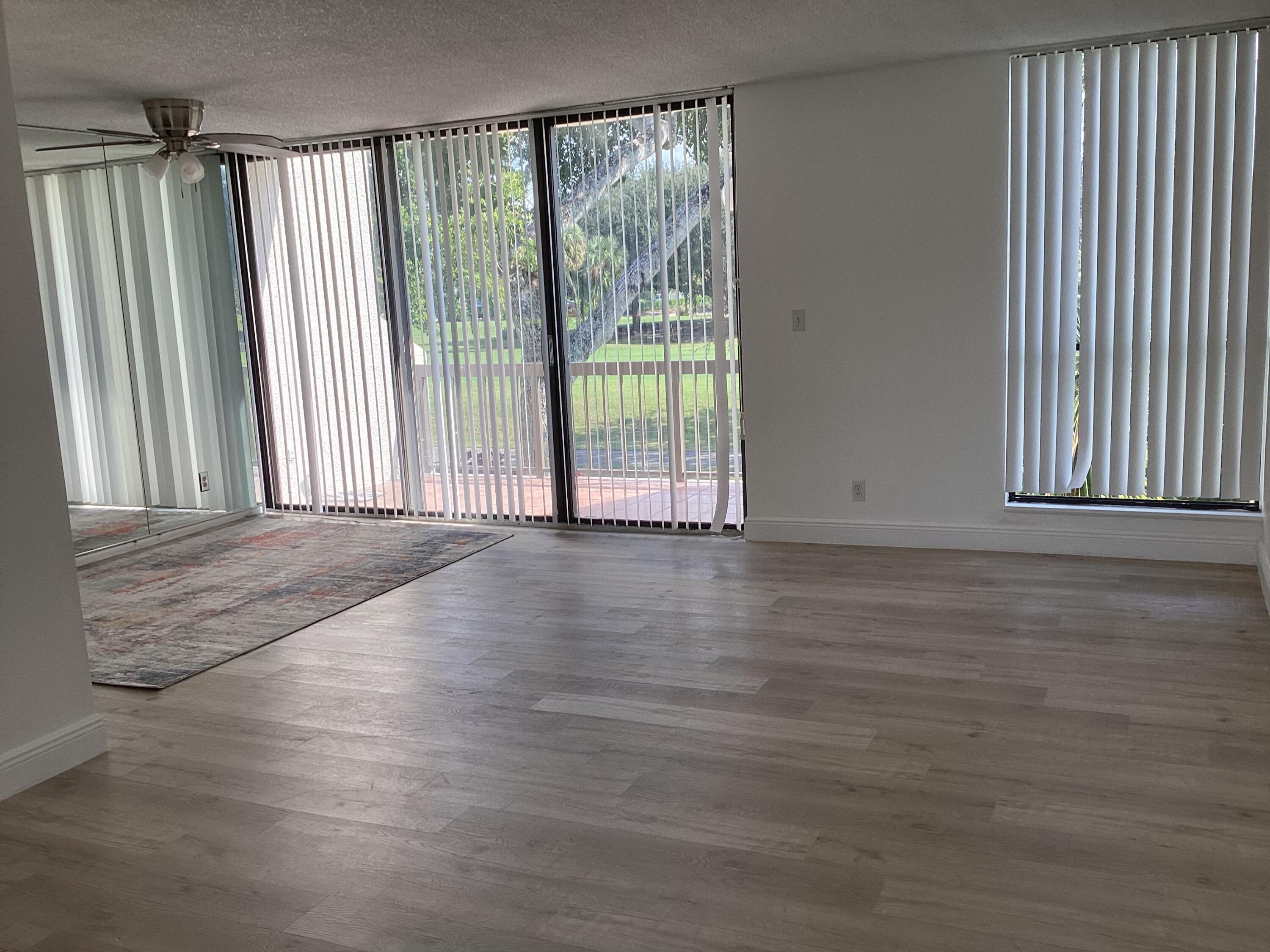 2308 Bridgewood Drive, Unit 2308 Boca Raton, FL 33434 - Photo 7 of 42 an empty room with wooden floor and windows