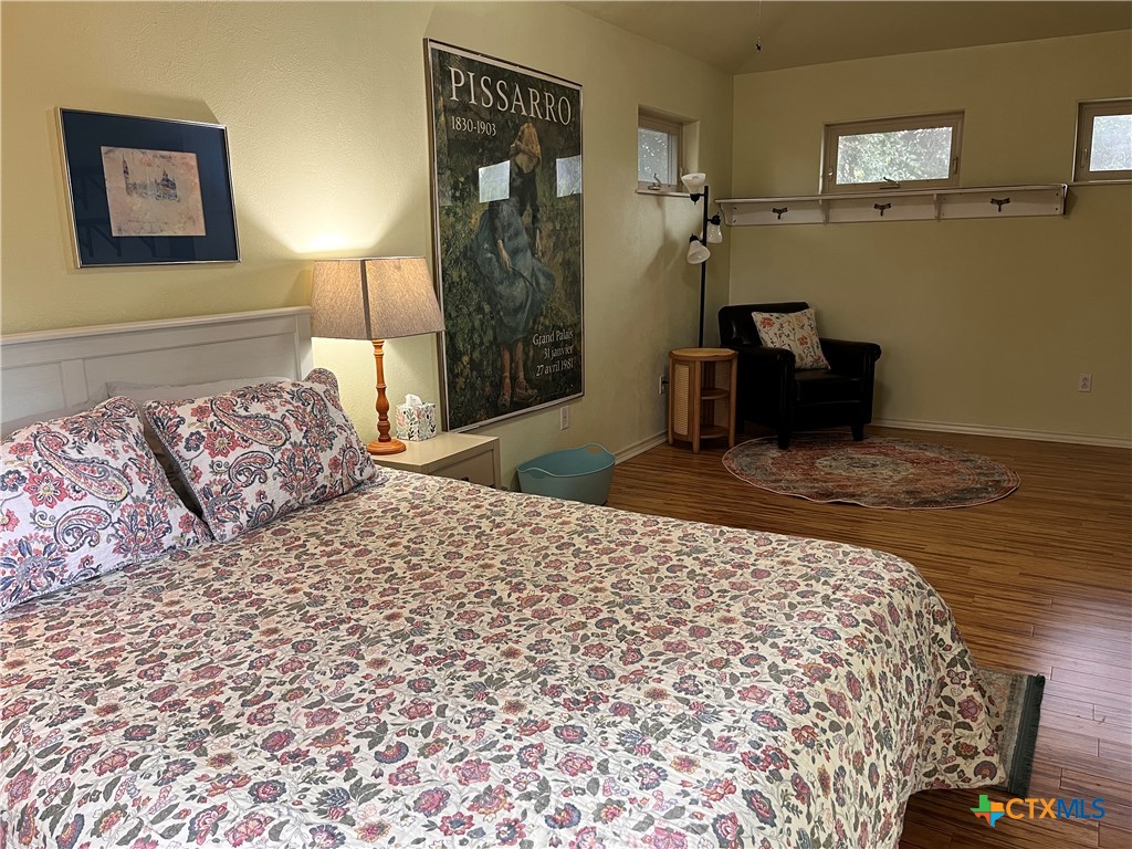 121 Butler Lane Martindale, TX 78655 - Photo 5 of 27 a bedroom with a bed and a lamp on dresser