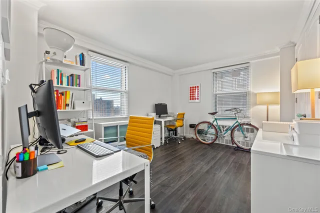 a view of a workspace with furniture a window and wooden floor
