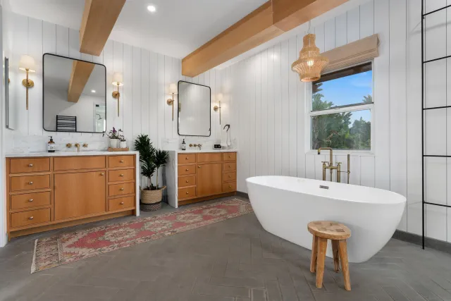 a spacious bathroom with a double vanity sink mirror and bathtub