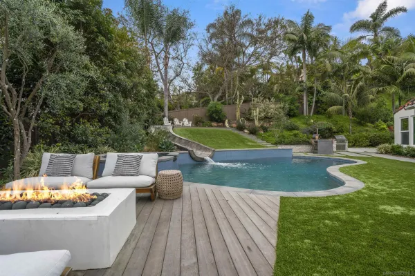 a view of a patio with couches dining table and chairs with wooden floor and fence