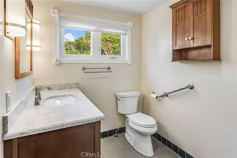 a bathroom with a granite countertop toilet sink and mirror