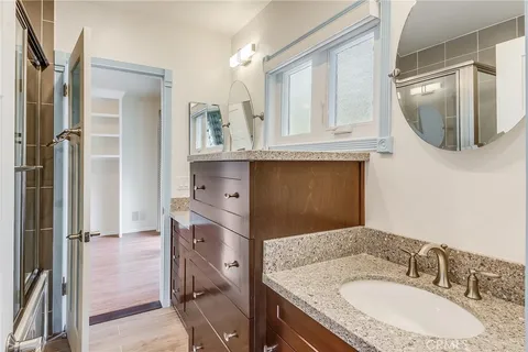 a en suite bathroom with a granite countertop sink and a mirror