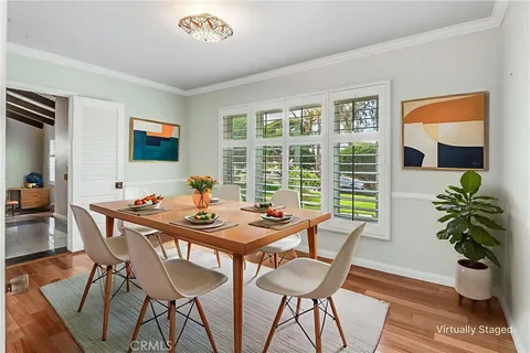 a dining room with furniture potted plants and wooden floor