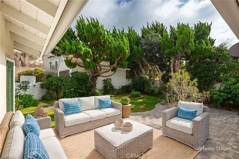 a view of a patio with couches and a potted plant on a table and chair