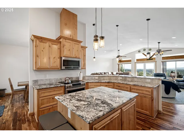 a kitchen with kitchen island granite countertop wooden cabinets and a stove