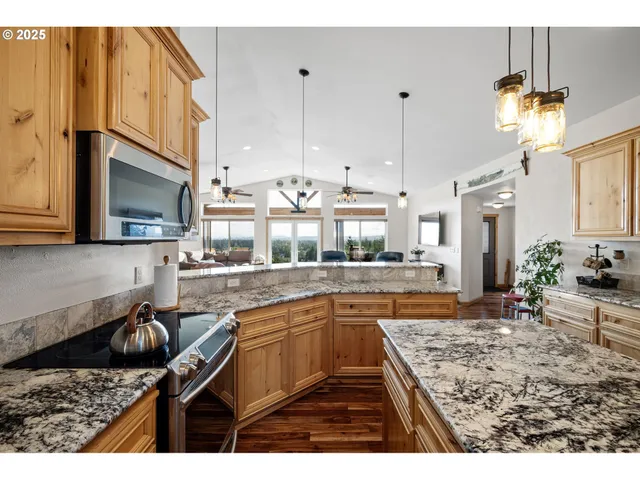 a kitchen with stainless steel appliances granite countertop a sink stove and cabinets