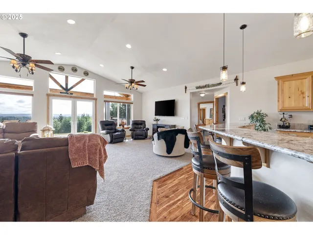 a living room with furniture a large window and flat screen tv