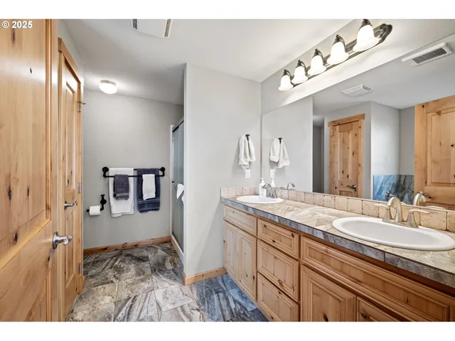 a bathroom with a sink double vanity granite and a mirror