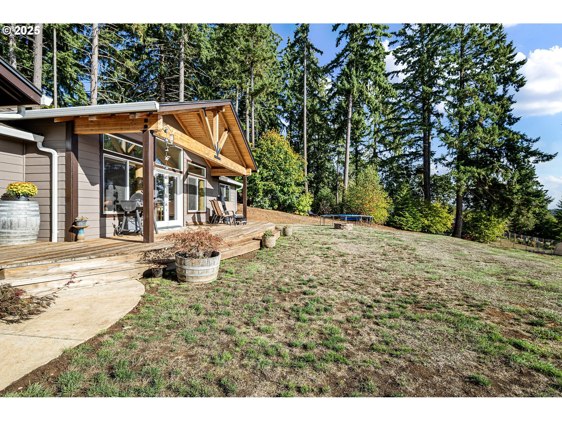 24674 Bolton Hill Road Veneta, OR 97487 - Photo 4 of 48 a backyard of a house with large trees and covered with wooden fence