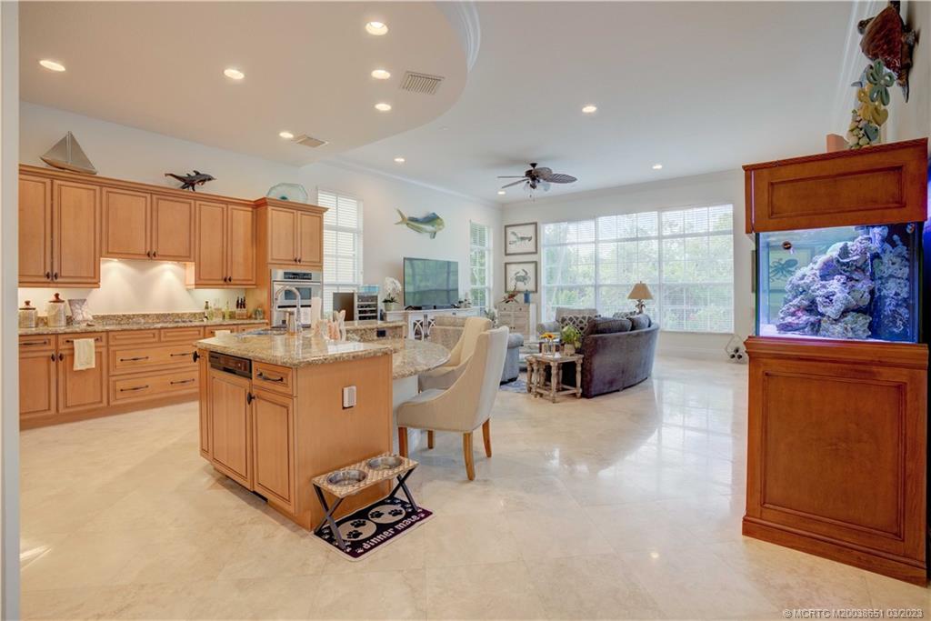 112 Tulip Tree Court Jupiter, FL 33458 - Photo 56 of 76 a kitchen with stainless steel appliances kitchen island granite countertop a stove and a refrigerator