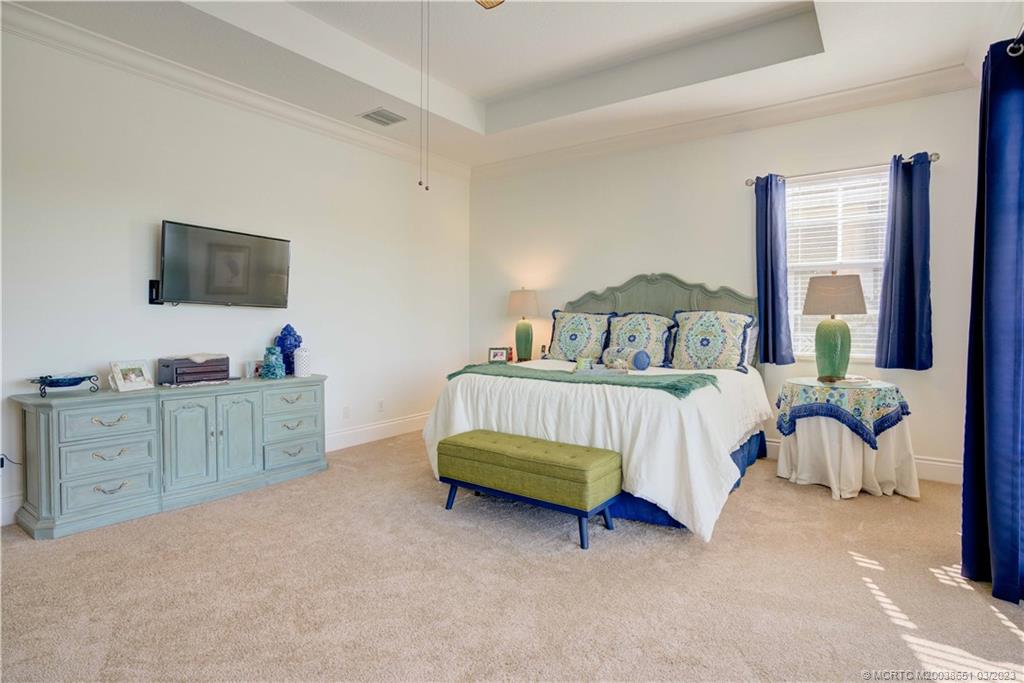 112 Tulip Tree Court Jupiter, FL 33458 - Photo 57 of 76 a bedroom with a bed and a flat tv screen on dresser