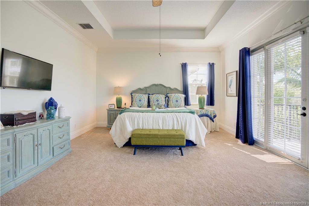 112 Tulip Tree Court Jupiter, FL 33458 - Photo 58 of 76 a bedroom with a bed and a flat tv screen on dresser