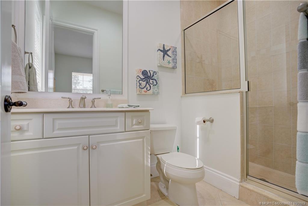 112 Tulip Tree Court Jupiter, FL 33458 - Photo 75 of 76 a bathroom with a granite countertop sink a toilet and a mirror