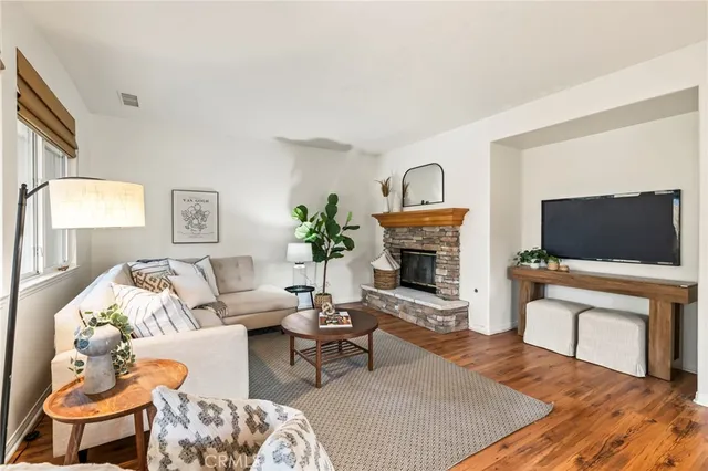 a living room with furniture a flat screen tv and a fireplace