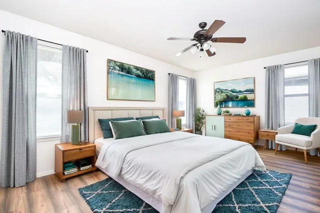 a view of empty room with wooden floor and ceiling fan