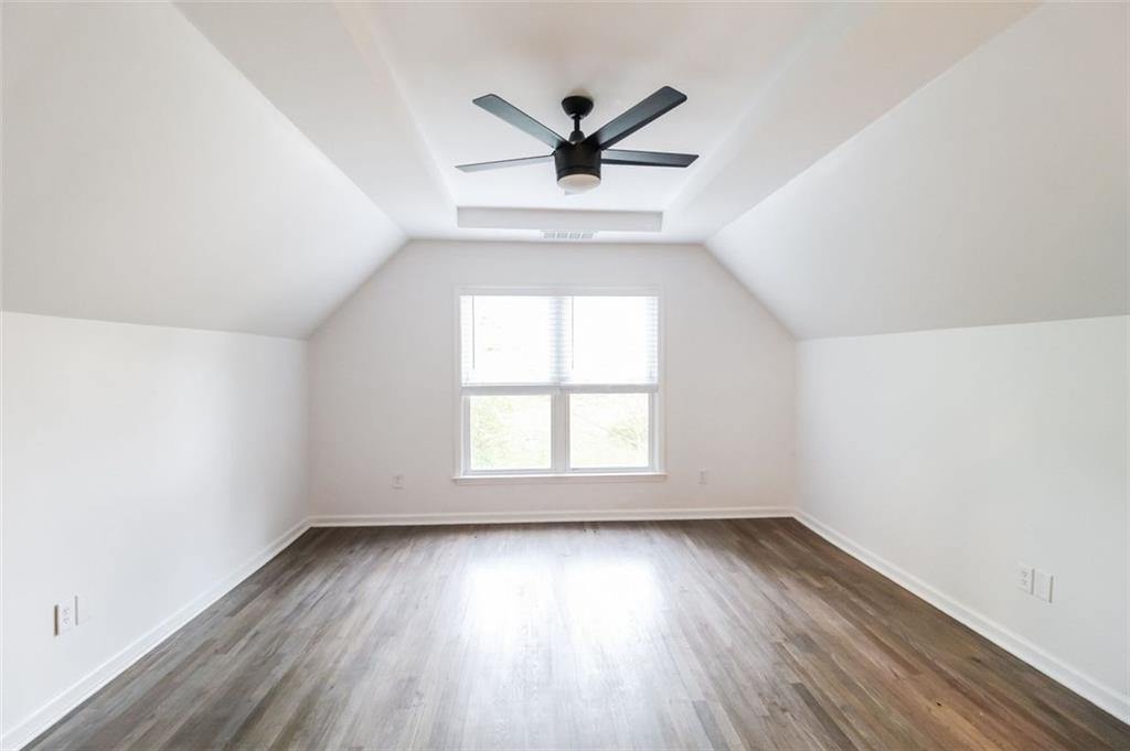 1070 4th Street Northwest Atlanta, GA 30318 - Photo 11 of 21 an empty room with wooden floor a ceiling fan and windows
