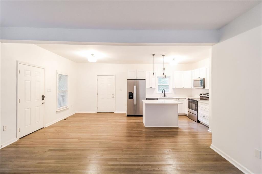 1070 4th Street Northwest Atlanta, GA 30318 - Photo 7 of 21 a view of a kitchen with kitchen island stainless steel appliances wooden floor and view living room