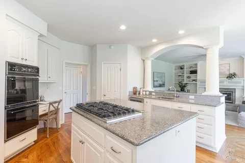 a kitchen with stainless steel appliances kitchen island granite countertop a table and chairs