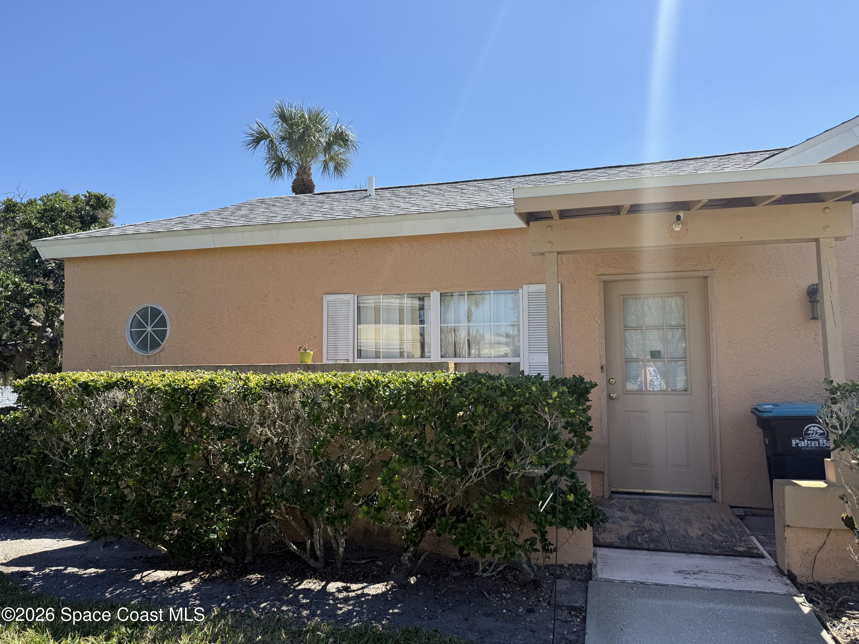 1490 Malibu Circle Northeast, Unit 112 Palm Bay, FL 32905 - Photo 1 of 6 a front view of a house with a yard