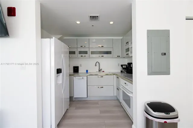 a kitchen with white cabinets and white appliances