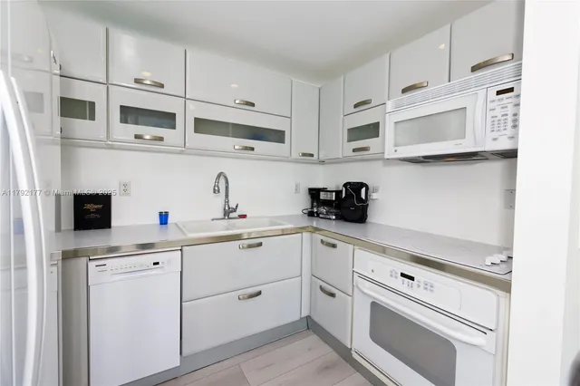 a kitchen with cabinets stainless steel appliances and sink