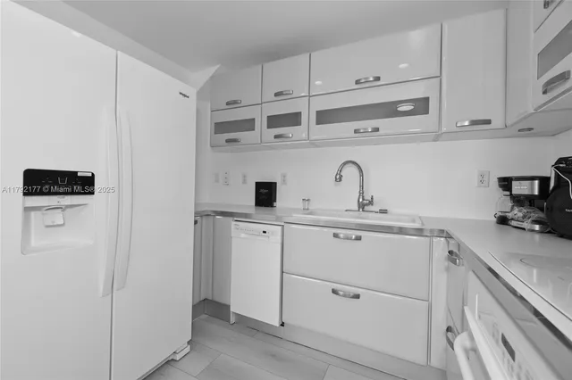a kitchen with cabinets stainless steel appliances and sink