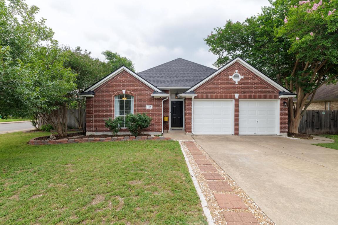 a front view of a house with a garden and yard