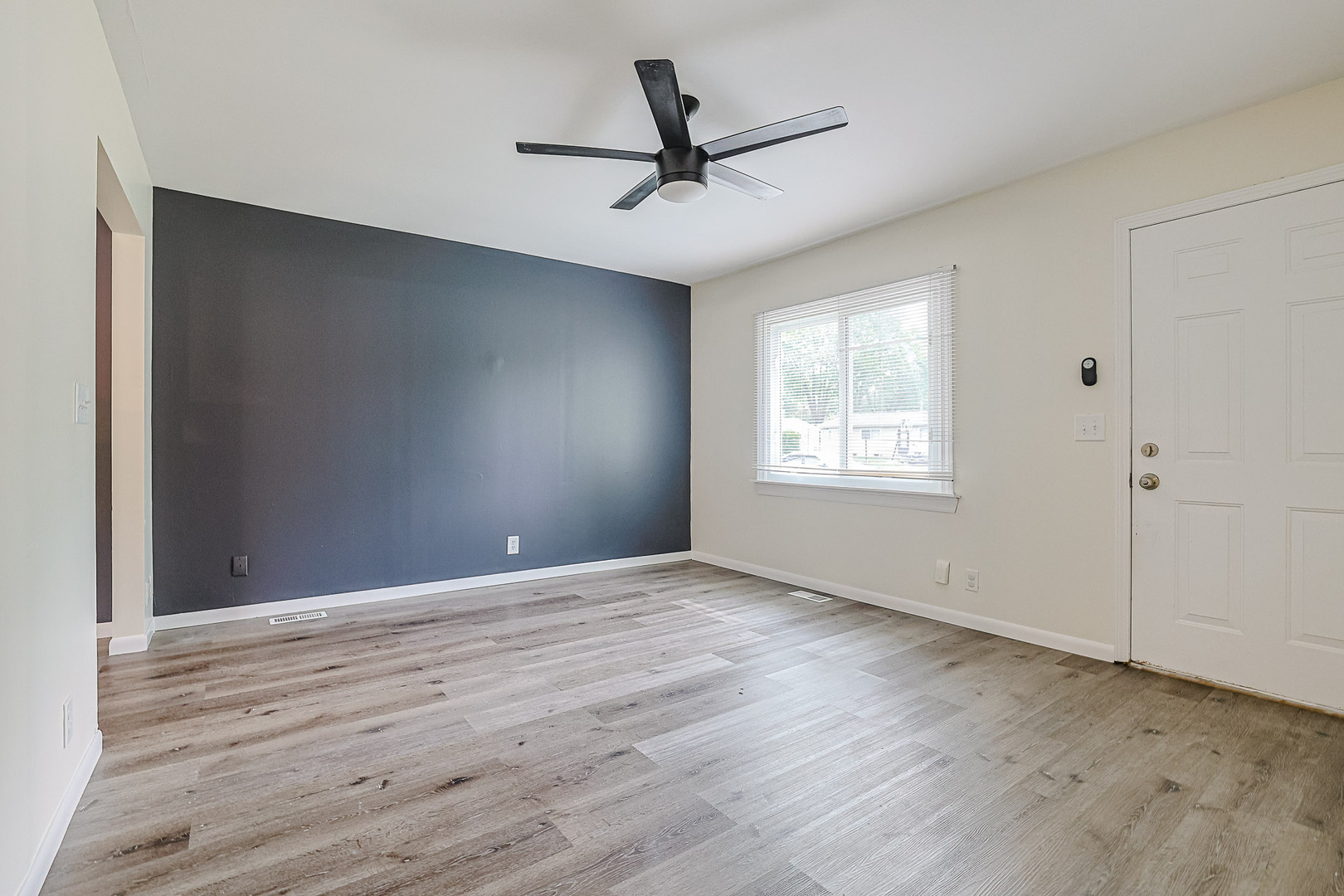 63 Sierra Road Montgomery, IL 60538 - Photo 5 of 22 an empty room with wooden floor ceiling fan and windows