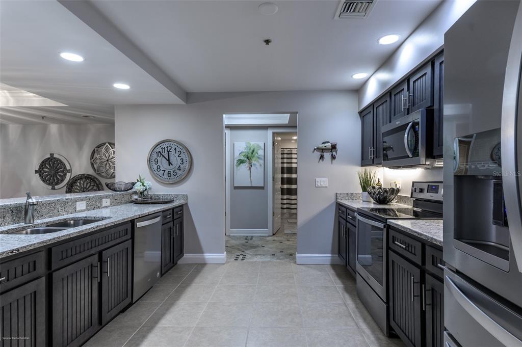 3313 Sunset Key Circle, Unit 107 Punta Gorda, FL 33955 - Photo 11 of 58 a kitchen with stainless steel appliances granite countertop a sink stove and refrigerator