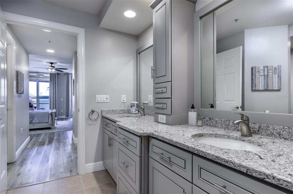 3313 Sunset Key Circle, Unit 107 Punta Gorda, FL 33955 - Photo 42 of 58 a bathroom with a granite countertop double vanity sink a mirror and a shower