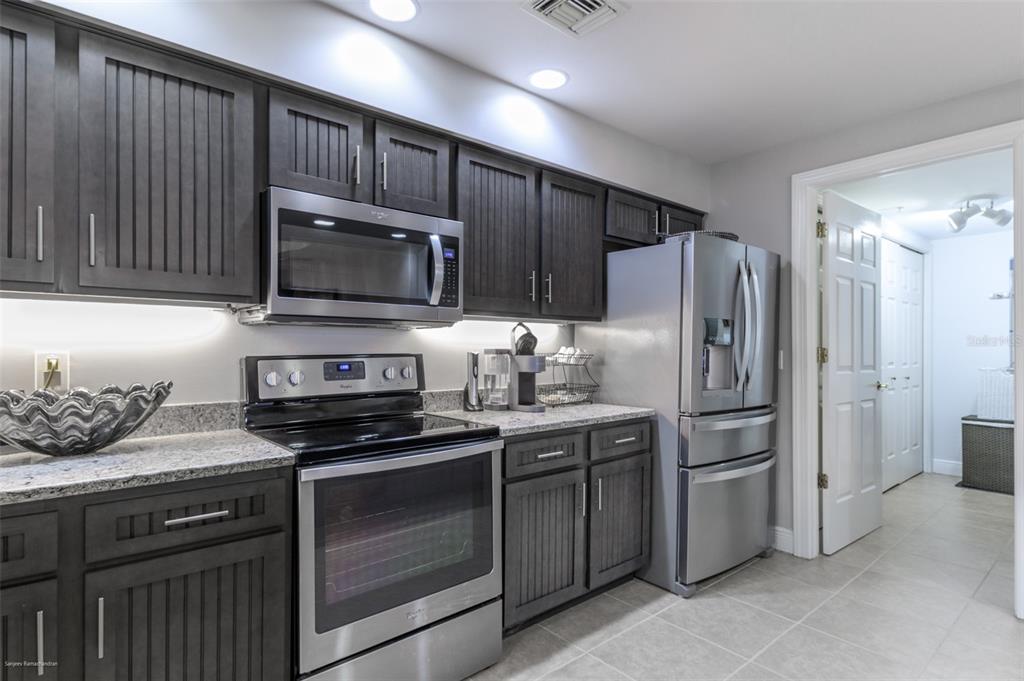 3313 Sunset Key Circle, Unit 107 Punta Gorda, FL 33955 - Photo 9 of 58 a kitchen with stainless steel appliances granite countertop a stove a refrigerator and a microwave