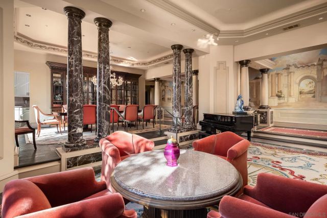 a outdoor dining room with furniture a chandelier and wooden floor
