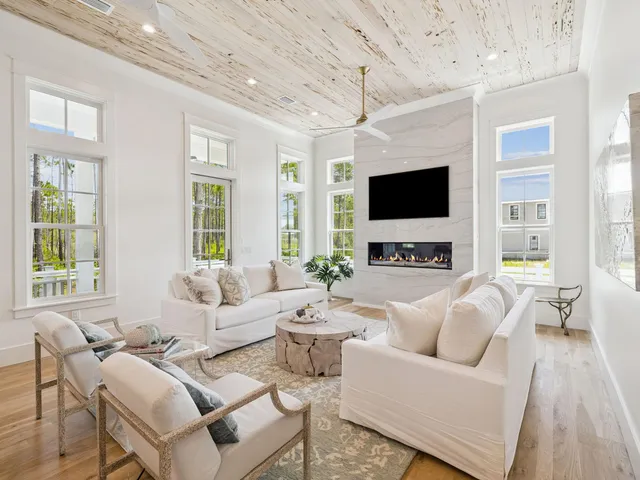 a living room with furniture a flat screen tv and a large window