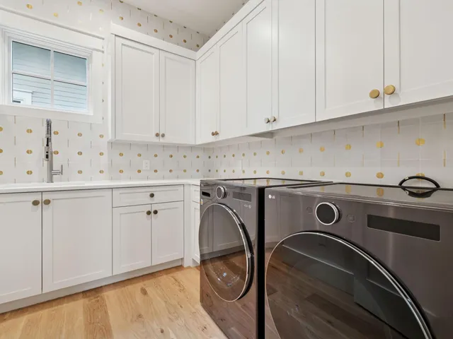 a utility room with granite countertop white cabinets washer and dryer