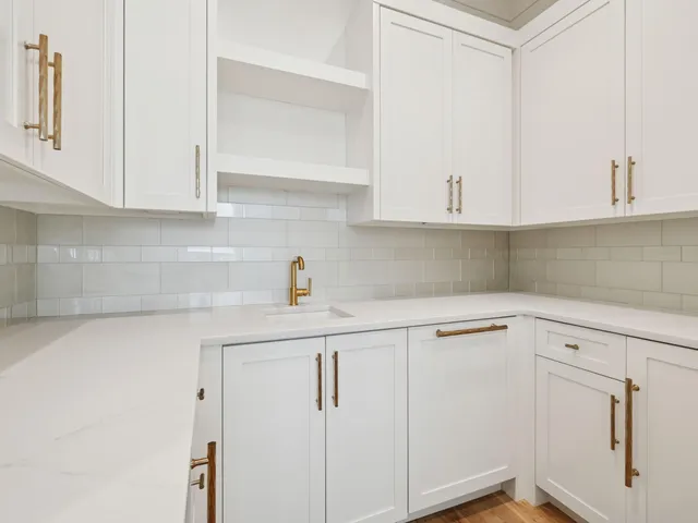 a kitchen with white cabinets and white appliances