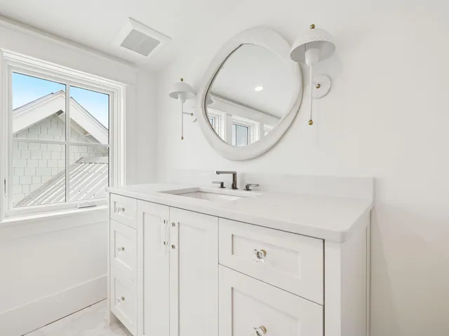a bathroom with a granite countertop double vanity sink and a mirror