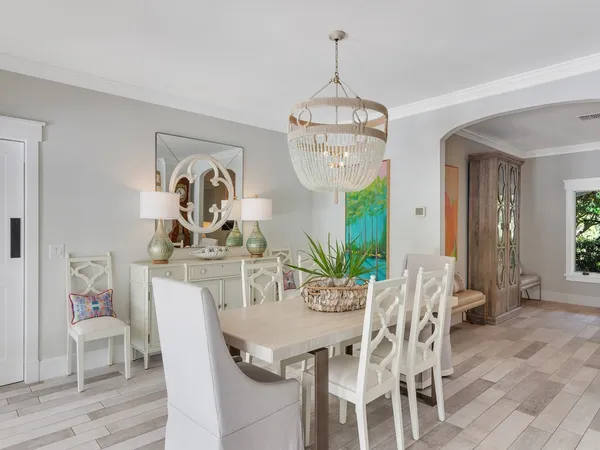 a view of a dining room with furniture a chandelier and wooden floor