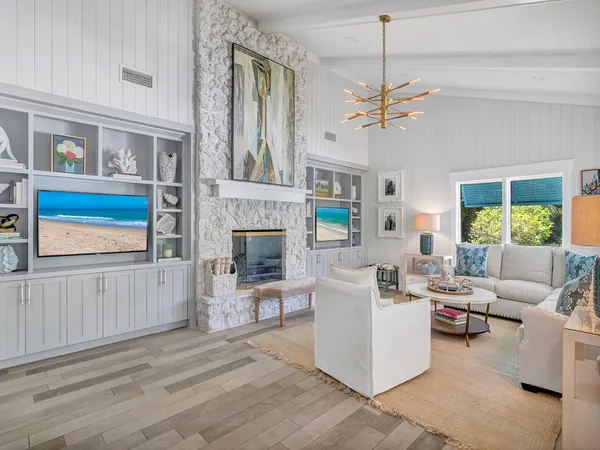 a living room with furniture a fireplace and a chandelier