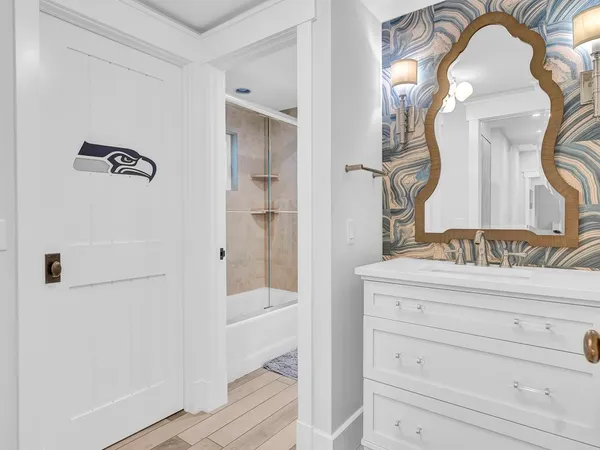 a bathroom with a granite countertop sink a mirror and shower