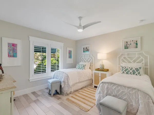 a bedroom with two beds and a large window