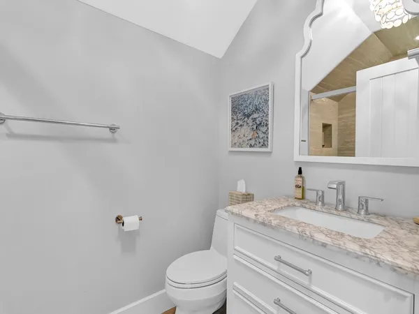 a bathroom with a granite countertop sink a toilet and a mirror