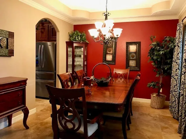 a view of a dining room with furniture and chandelier