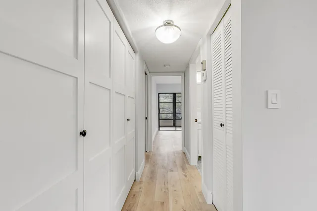 a view of a hallway with wooden floor and staircase