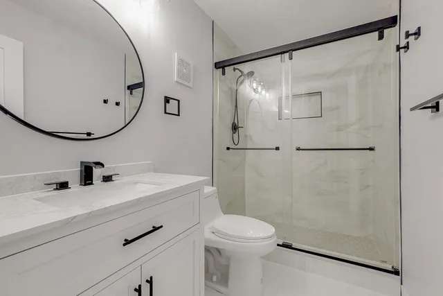 a bathroom with a sink mirror toilet and shower