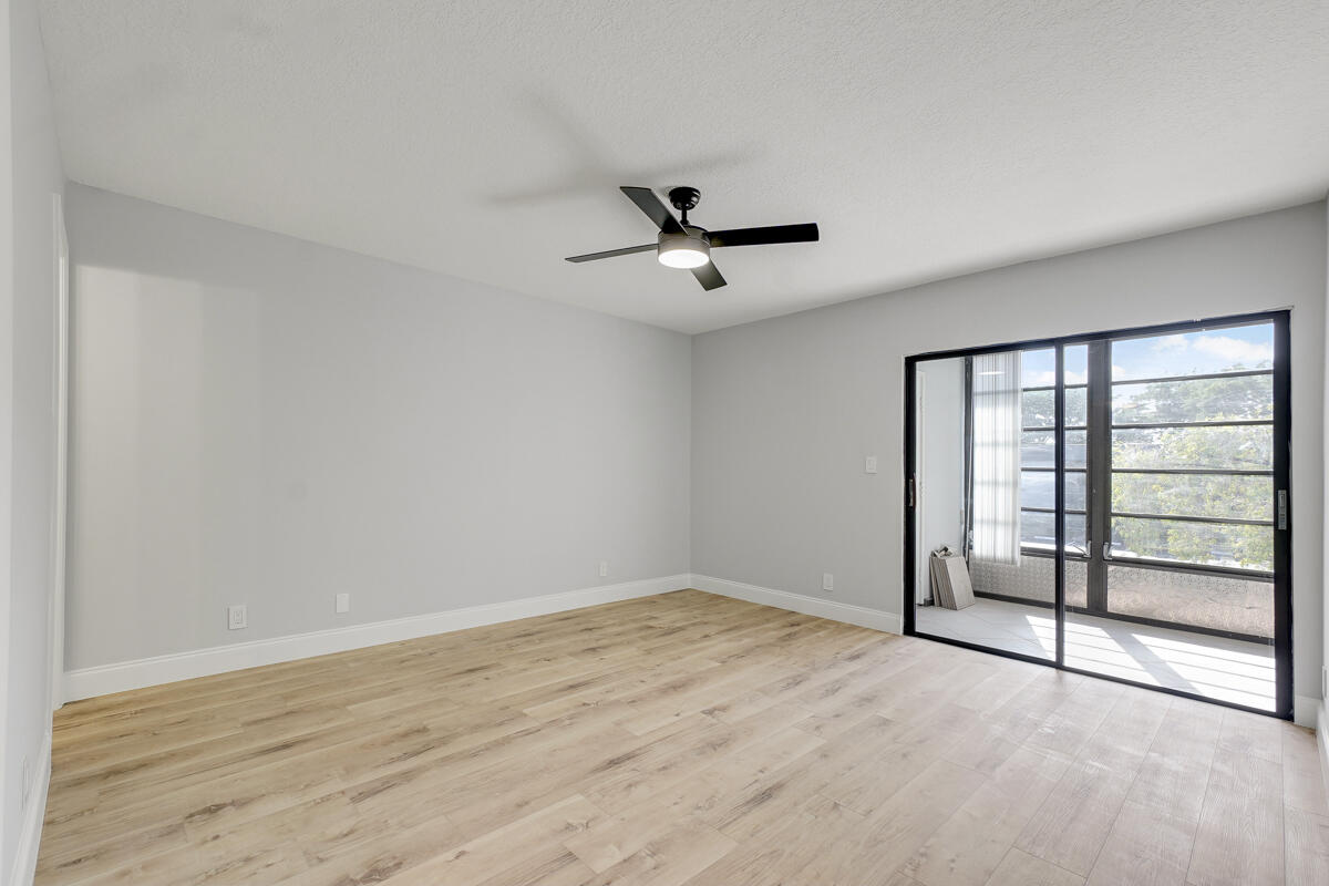 15072 Ashland Place, Unit 132 Delray Beach, FL 33484 - Photo 16 of 38 wooden floor in an empty room with a window