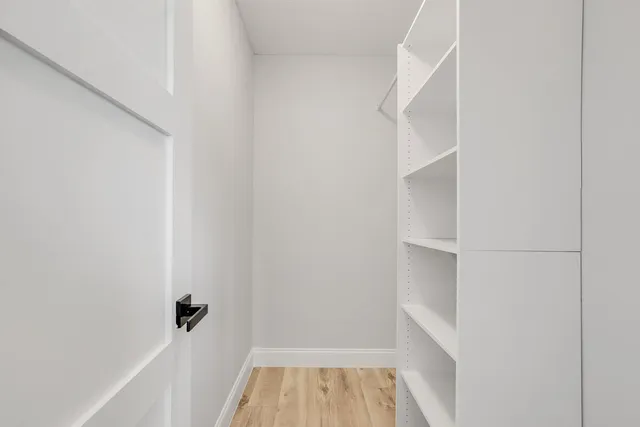 a view of walk in closet with empty racks