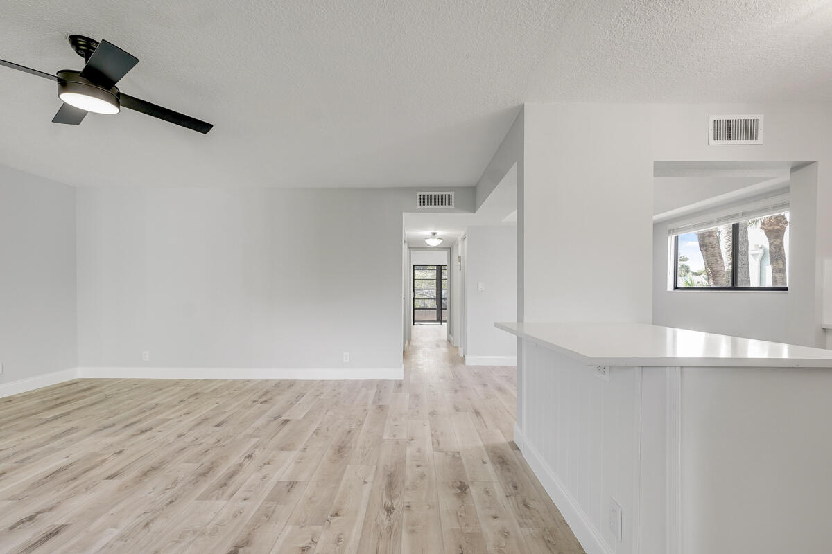 15072 Ashland Place, Unit 132 Delray Beach, FL 33484 - Photo 8 of 38 wooden floor in an empty room with a window