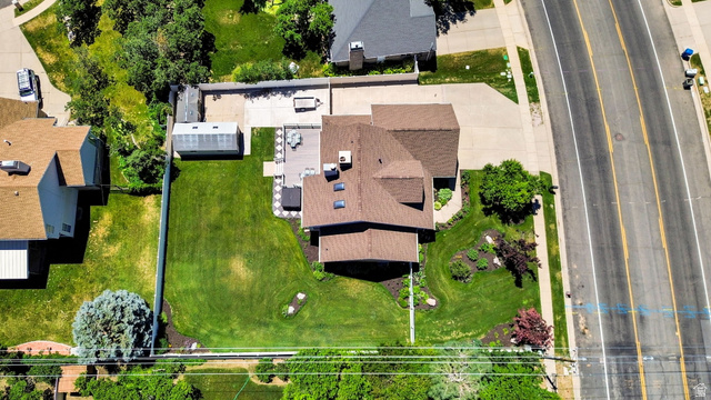4792 Glasmann Way South Ogden, UT 84403 - Photo 10 of 70 Expansive residential property featuring a large green lawn, a deck, a detached sheds, a concrete patio, and mature landscaping